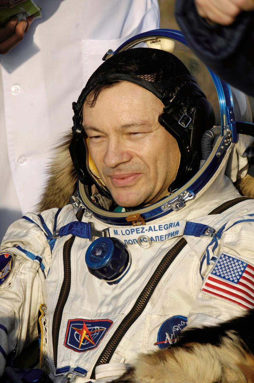 JSC2007-E-19321 (21 April 2007) --- Astronaut Michael E. Lopez-Alegria, Expedition 14 commander and NASA station science officer, sits in a chair near the Soyuz TMA-9 spacecraft at the landing site. Landing and recovery officials were conducting post-landing medical checks on the three crewmembers. The Soyuz spacecraft landed southwest of Karaganda, Kazakhstan at approximately 6:30 p.m. local time, April 21, 2007. Photo Credit: NASA/Bill Ingalls