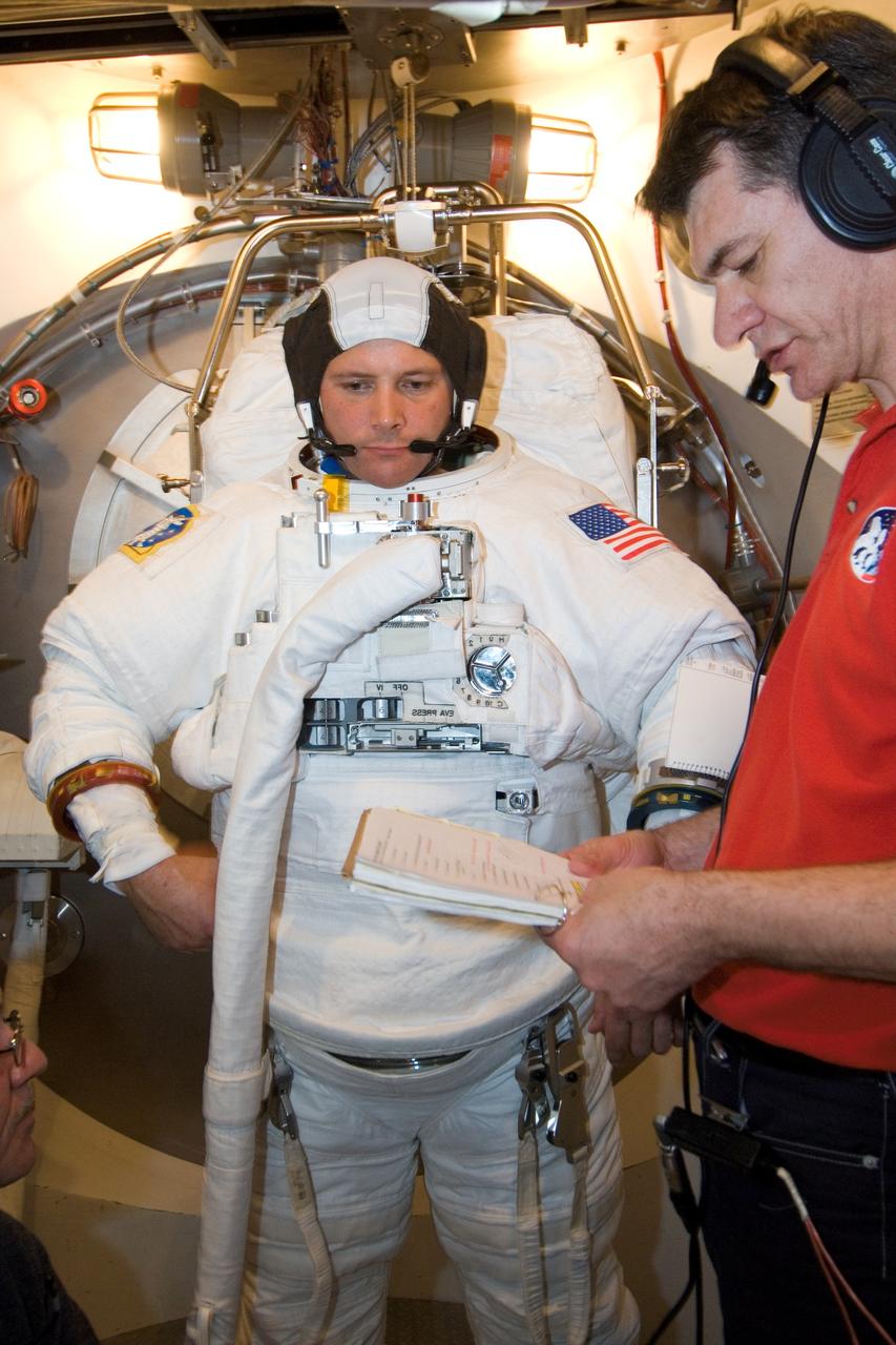JSC2007-E-20540 (26 April 2007) --- Astronaut Douglas H. Wheelock, STS-120 mission specialist, participates in an Extravehicular Mobility Unit (EMU) spacesuit fit check in the Space Station Airlock Test Article (SSATA) in the Crew Systems Laboratory at the Johnson Space Center. European Space Agency (ESA) astronaut Paolo Nespoli, mission specialist, assisted Wheelock.