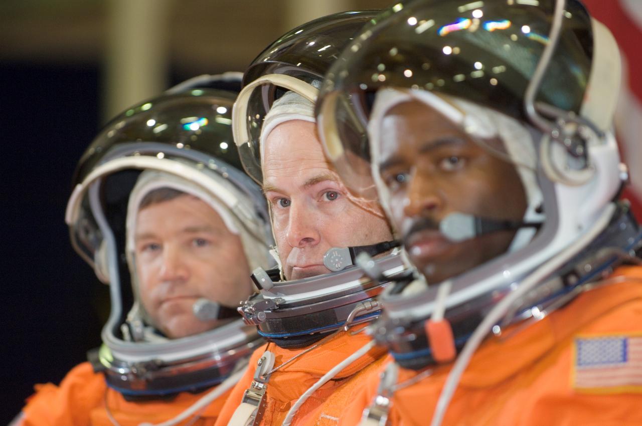 JSC2007-E-21250 (1 May 2007) --- Astronauts Stephen N. Frick (left), STS-122 commander; Alan G. Poindexter, pilot; and Leland D. Melvin, mission specialist, await the start of an emergency egress training session in the Space Vehicle Mockup Facility at Johnson Space Center. The crewmembers are wearing training versions of their shuttle launch and entry suits.