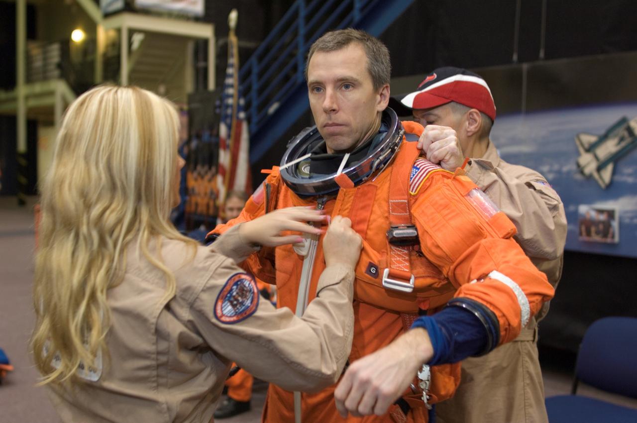 JSC2008-E-008444 (29 Jan. 2008) --- Astronaut Andrew J. Feustel, STS-125 mission specialist, dons a training version of his shuttle launch and entry suit in preparation for a training session in the Space Vehicle Mockup Facility at Johnson Space Center. United Space Alliance (USA) suit technicians Nicole Everett and Steve Cortinas assisted Feustel.