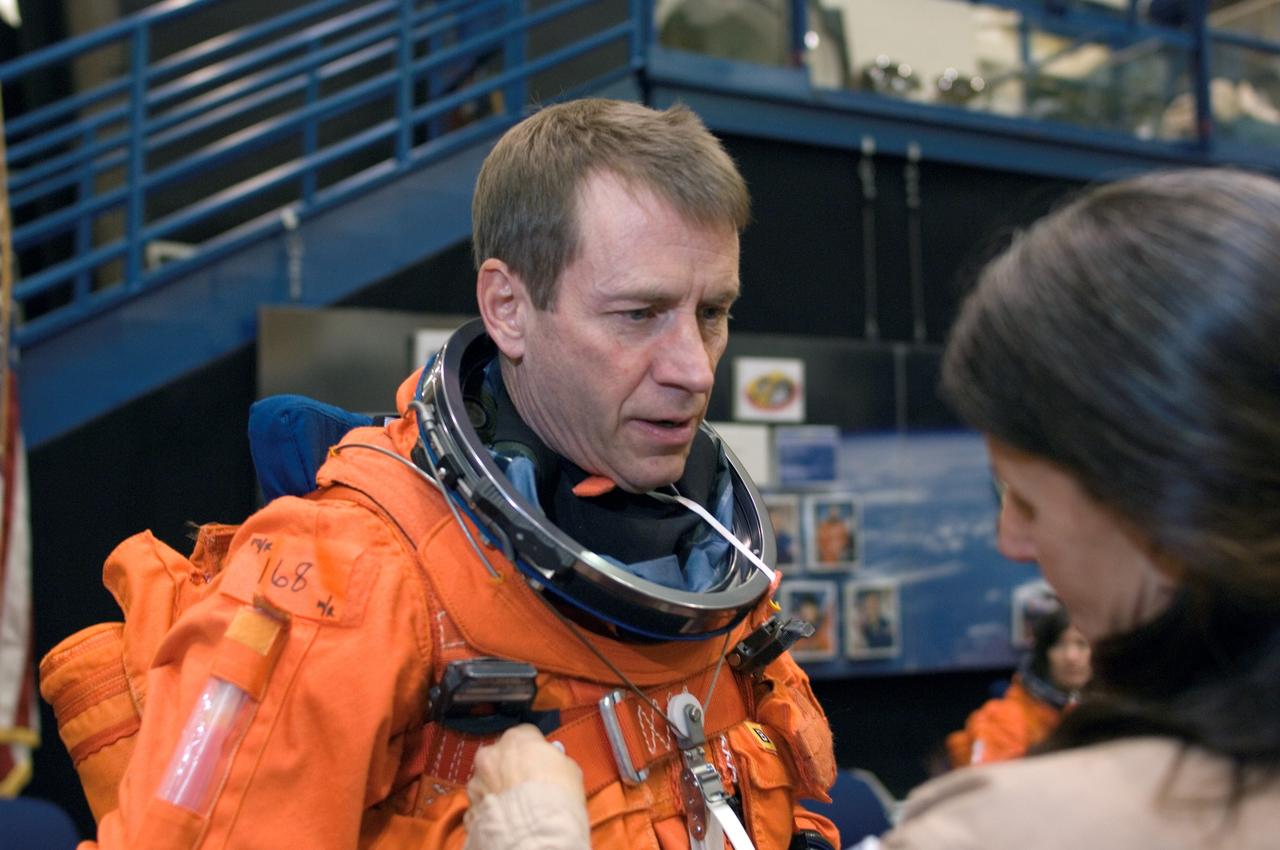 JSC2008-E-008454 (29 Jan. 2008) --- Astronaut Gregory C. Johnson, STS-125 pilot, dons a training version of his shuttle launch and entry suit in preparation for a training session in the Space Vehicle Mockup Facility at Johnson Space Center. United Space Alliance (USA) suit technician Toni Cost-Davis assisted Johnson.