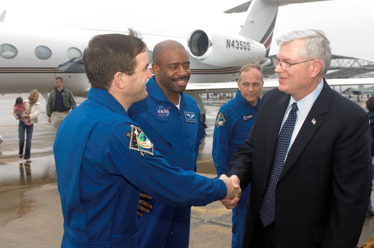 JSC2008-E-014908 (21 Feb. 2008) --- Johnson Space Center's (JSC) director Michael L. Coats (right) greets astronauts Rex Walheim (left) and Leland Melvin, STS-122 mission specialists, at Ellington Field near JSC prior to the STS-122 crew return ceremonies. European Space Agency (ESA) astronaut Hans Schlegel, mission specialist, is visible in the background.