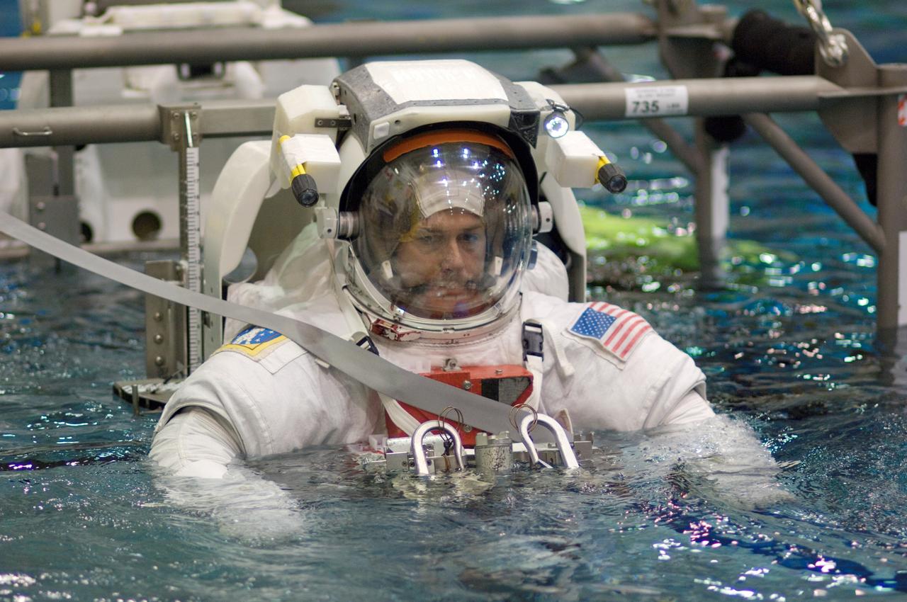 JSC2008-E-015735 (26 Feb. 2008) --- Astronauts Robert S. (Shane) Kimbrough and Stephen G. Bowen (partially obscured), both STS-126 mission specialists, are submerged in the waters of the Neutral Buoyancy Laboratory (NBL) near Johnson Space Center. Kimbrough and Bowen are attired in training versions of the Extravehicular Mobility Unit (EMU) spacesuit. SCUBA-equipped divers (out of frame) are in the water to assist the crewmembers in their rehearsal, intended to help prepare them for work on the exterior of the International Space Station.