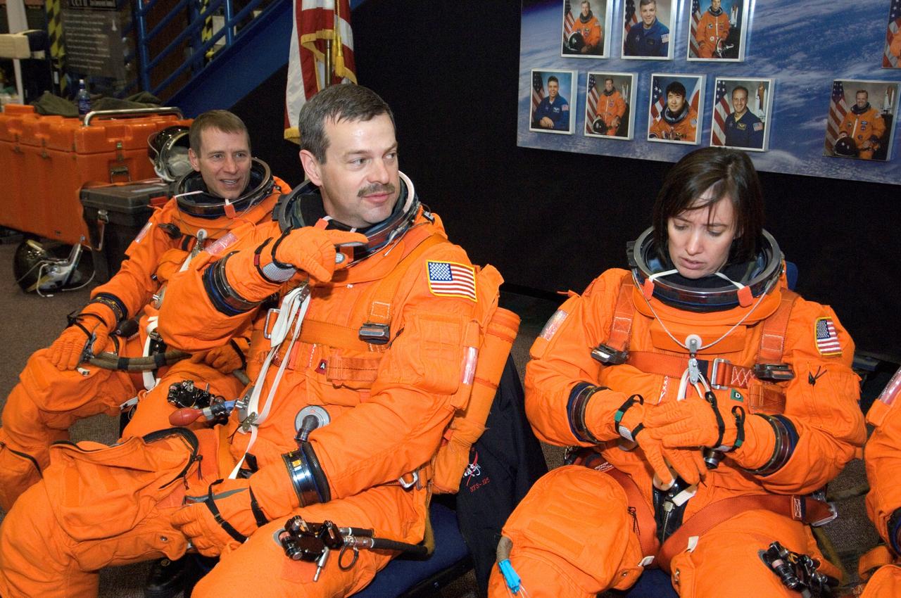 JSC2008-E-018339 (27 Feb. 2008) --- Attired in training versions of their shuttle launch and entry suits, astronauts Scott D. Altman (center), STS-125 commander; Gregory C. Johnson (left), pilot; and K. Megan McArthur, mission specialist, await the start of a training session in the Space Vehicle Mockup Facility at Johnson Space Center.