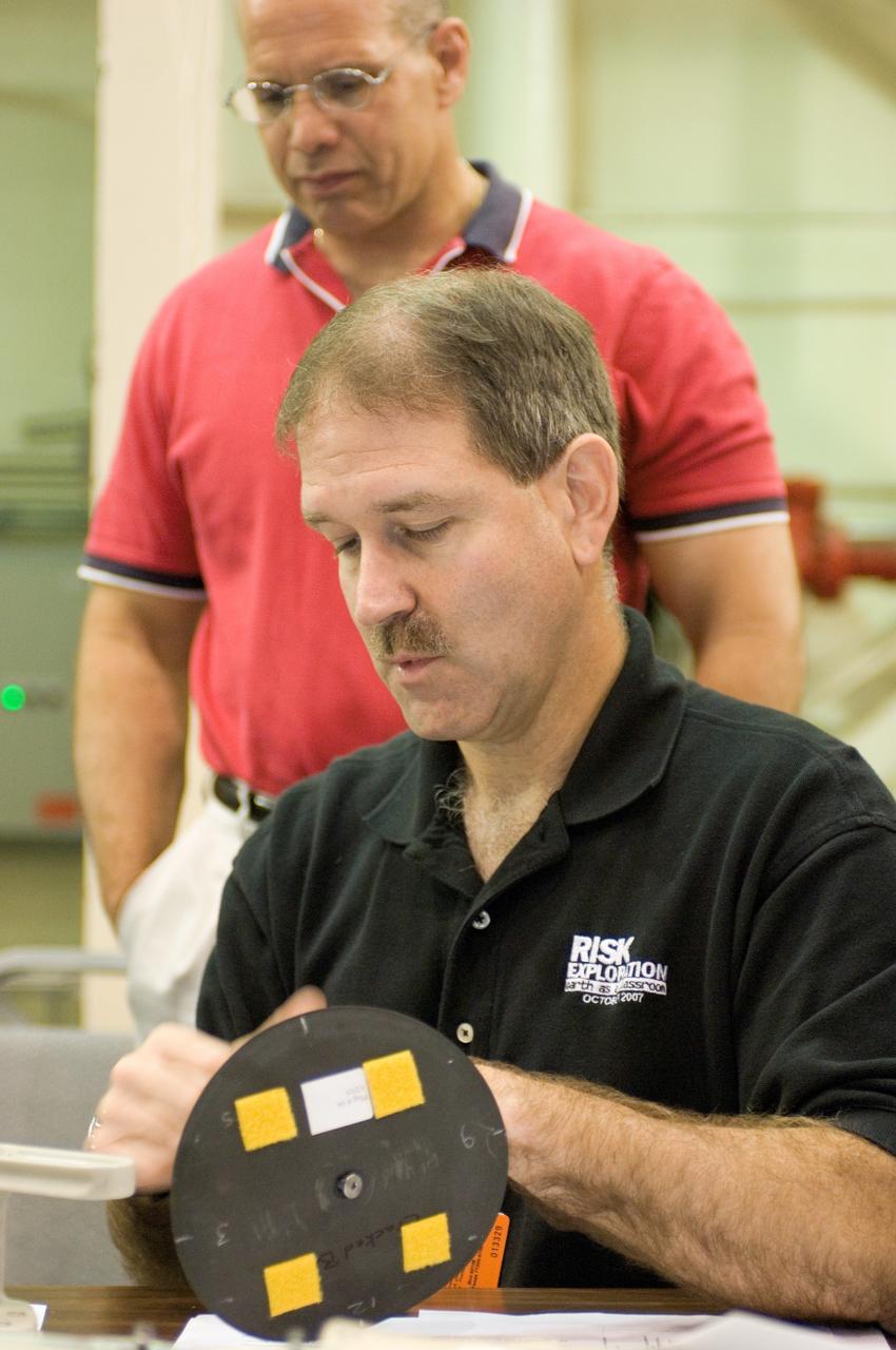 JSC2008-E-031810 (2 April 2008) --- Astronauts John M. Grunsfeld, STS-125 mission specialist, participates in an extravehicular activity (EVA) hardware training session in the Space Vehicle Mockup Facility at NASA's Johnson Space Center. Flight director Tony Ceccacci looks on.