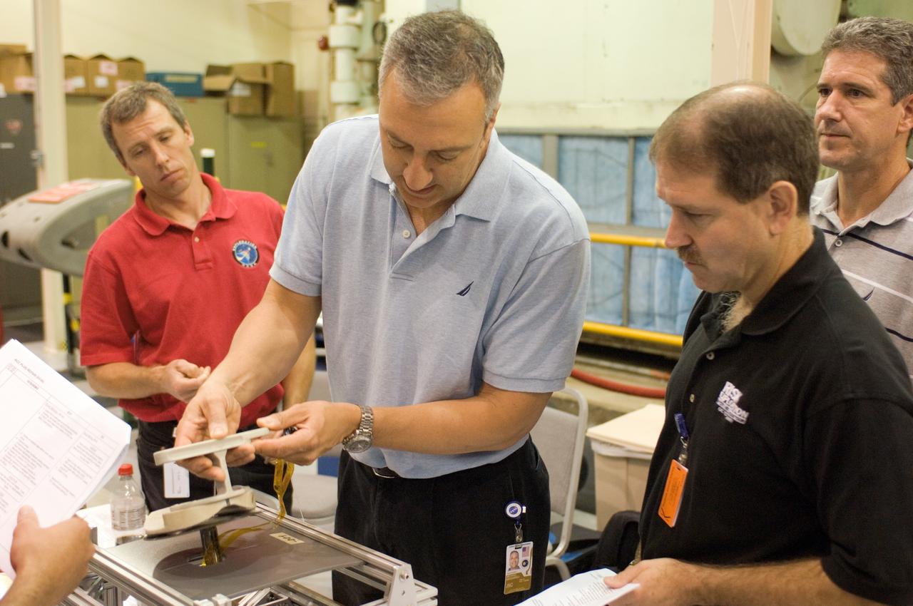 JSC2008-E-031815 (2 April 2008) --- Astronauts Michael J. Massimino (center), John M. Grunsfeld (right), Michael T. Good (right background) and Andrew J. Feustel, all STS-125 mission specialists, participate in an extravehicular activity (EVA) hardware training session in the Space Vehicle Mockup Facility at NASA's Johnson Space Center.