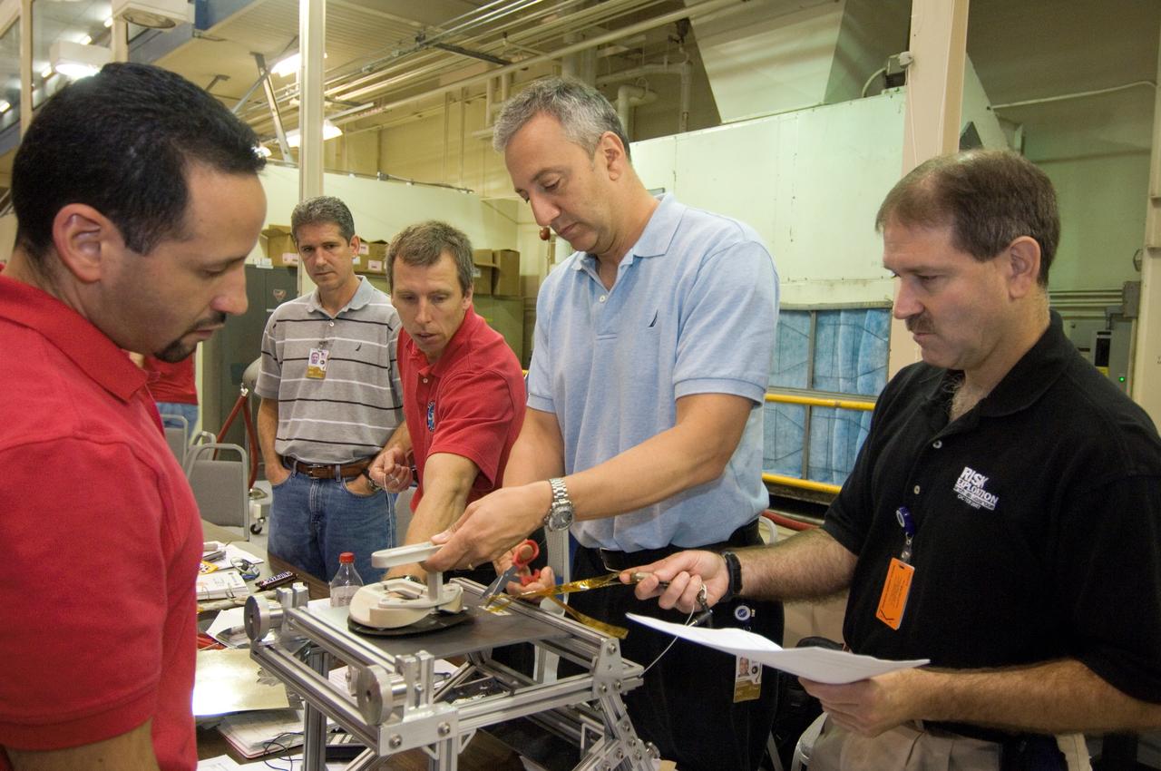 JSC2008-E-031816 (2 April 2008) --- Astronauts John M. Grunsfeld (right), Michael J. Massimino, Andrew J. Feustel and Michael T. Good, all STS-125 mission specialists, participate in an extravehicular activity (EVA) hardware training session in the Space Vehicle Mockup Facility at NASA's Johnson Space Center. Tomas Gonzalez-Torres (left) assisted the crewmembers.