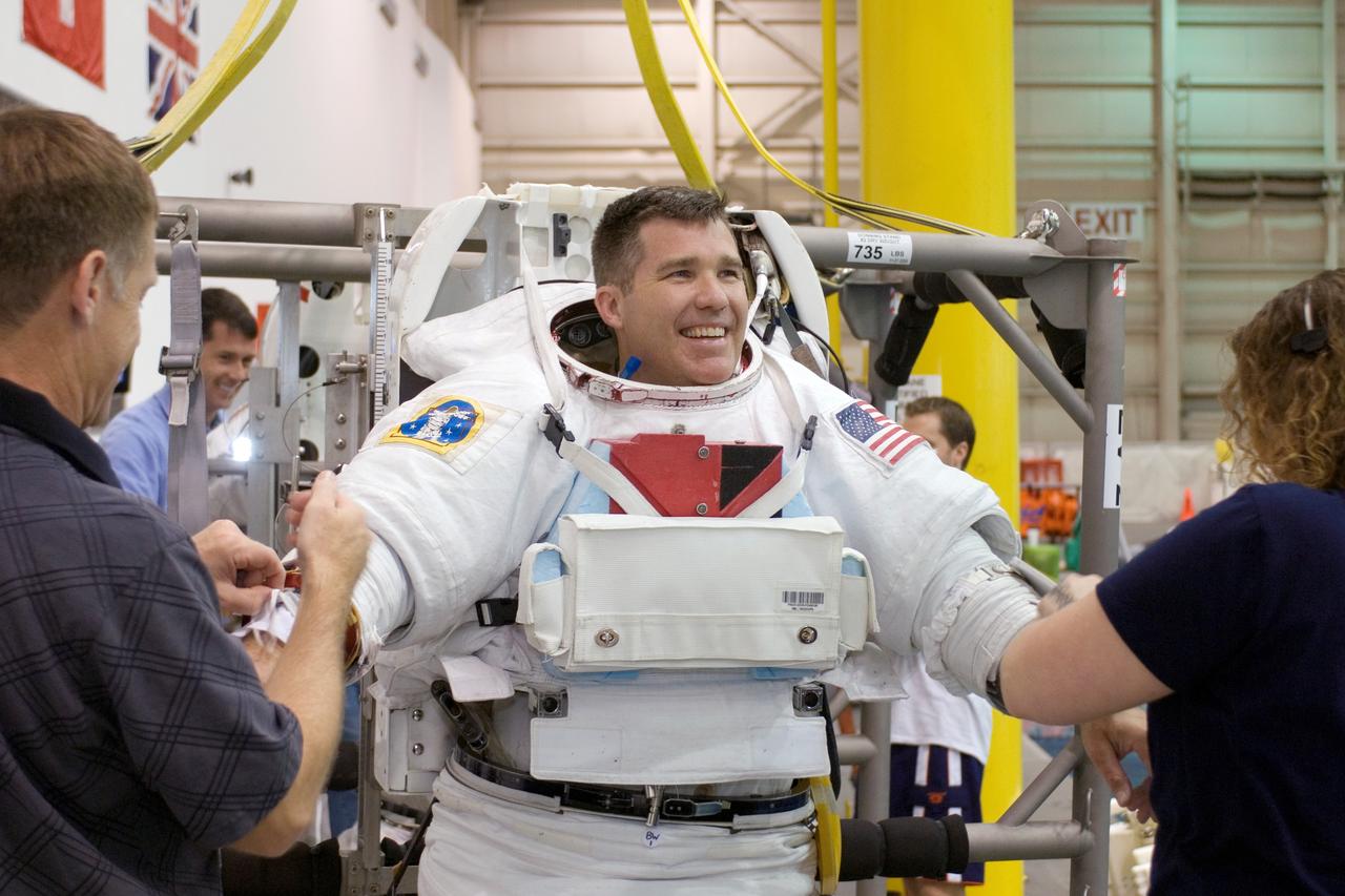 JSC2008-E-031867 (3 April 2008) --- Astronaut Stephen G. Bowen, STS-126 mission specialist, dons a training version of the Extravehicular Mobility Unit (EMU) spacesuit in preparation for a training session in the waters of the Neutral Buoyancy Laboratory (NBL) near NASA's Johnson Space Center. Astronaut Christopher J. Ferguson (left), commander, and a suit technician assisted Bowen.