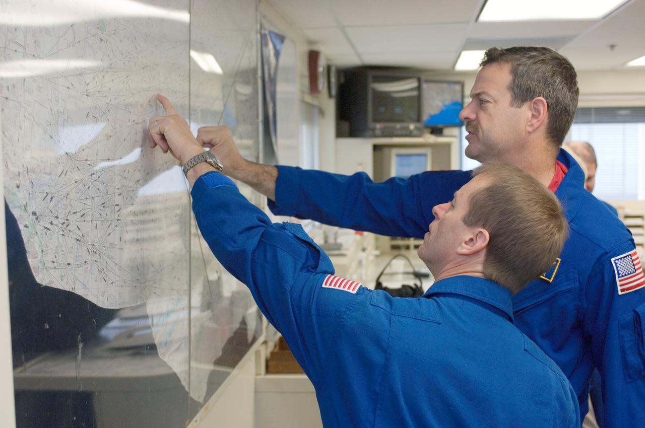 JSC2008-E-035351 (17 April 2008) --- Astronauts Scott D. Altman and Gregory C. Johnson (foreground), STS-125 commander and pilot, respectively, look over their flight plan in the check-out facility at Ellington Field near NASA's Johnson Space Center prior to a flight in NASA T-38 trainer jets.