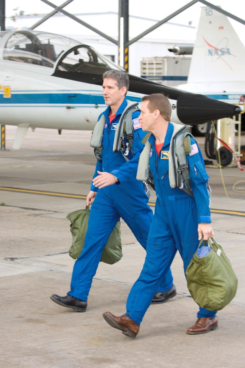 JSC2008-E-035357 (17 April 2008) --- Astronauts Gregory C. Johnson (right), STS-125 pilot, and Michael T. Good, mission specialist, walk to the nearby flight line of NASA T-38 trainer jets at Ellington Field near NASA's Johnson Space Center.
