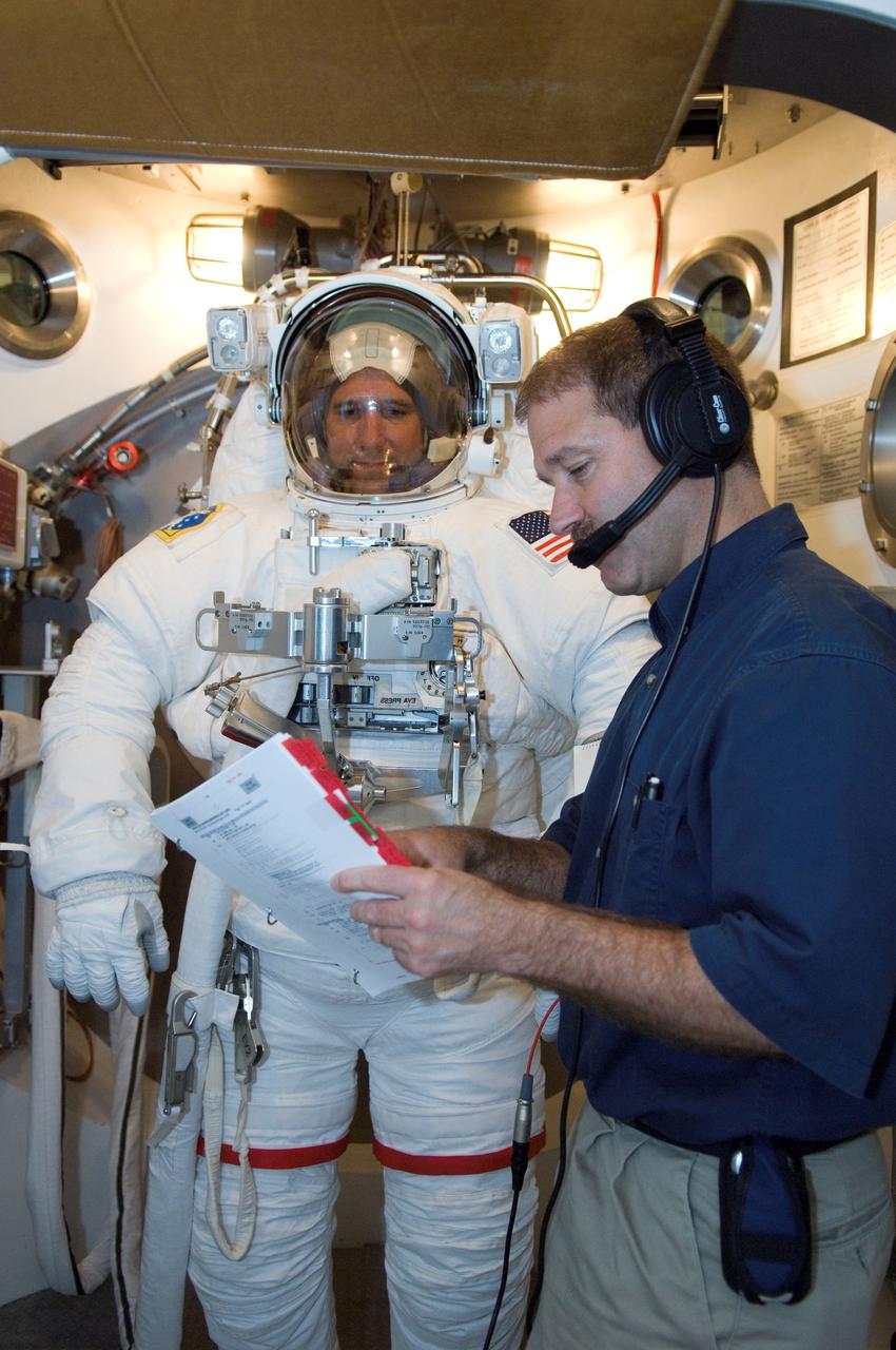 JSC2008-E-035897 (22 April 2008) --- Astronaut Michael T. Good, STS-125 mission specialist, participates in an Extravehicular Mobility Unit (EMU) spacesuit fit check in the Space Station Airlock Test Article (SSATA) in the Crew Systems Laboratory at NASA's Johnson Space Center. Astronaut John M. Grunsfeld, mission specialist, assisted Good.