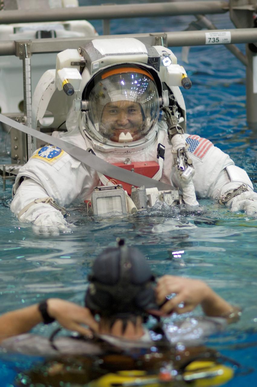 JSC2008-E-039255 (12 May 2008) --- Japan Aerospace Exploration Agency (JAXA) astronaut Koichi Wakata, Expedition 18 flight engineer, and NASA astronaut Edward M. (Mike) Fincke (partially obscured), commander, are about to be submerged in the waters of the Neutral Buoyancy Laboratory (NBL) near NASA's Johnson Space Center. Wakata and Fincke are attired in training versions of the Extravehicular Mobility Unit (EMU) spacesuit. SCUBA-equipped divers are in the water to assist the crewmembers in their rehearsal, intended to help prepare them for work on the exterior of the International Space Station.