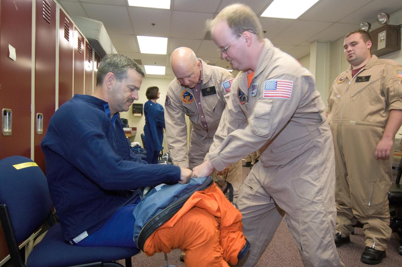 JSC2008-E-047945 (4 June 2008) --- Astronaut Scott D. Altman, STS-125 commander, dons a training version of his shuttle launch and entry suit in preparation for a training session in the Space Vehicle Mockup Facility at NASA's Johnson Space Center. United Space Alliance suit technicians Daniel Palmer (foreground) assisted Altman.