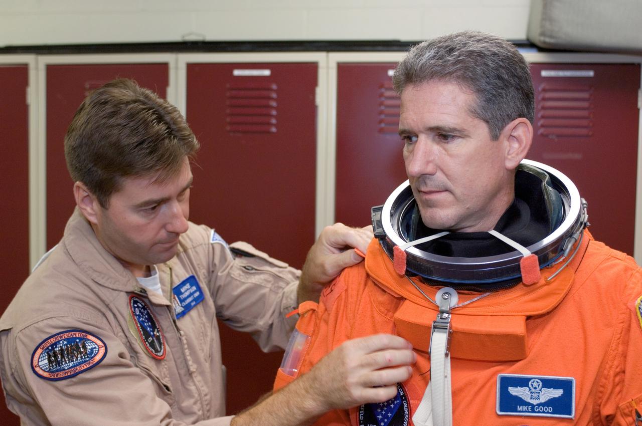 JSC2008-E-047956 (4 June 2008) --- Astronaut Michael T. Good, STS-125 mission specialist, dons a training version of his shuttle launch and entry suit in preparation for a training session in the Space Vehicle Mockup Facility at NASA's Johnson Space Center. United Space Alliance suit technician Mike Thompson assisted Good.