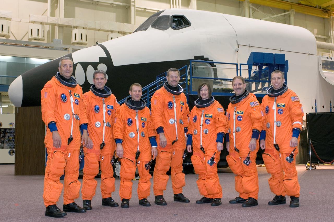 JSC2008-E-047961 (4 June 2008) --- The STS-125 crewmembers take a moment to pose for a crew photo prior to a training session in the Space Vehicle Mockup Facility at NASA's Johnson Space Center. From the left are astronauts Michael J. Massimino, Michael T. Good, both mission specialists; Gregory C. Johnson, pilot; Scott D. Altman, commander; K. Megan McArthur, John M. Grunsfeld and Andrew J. Feustel, all mission specialists. The crewmembers are wearing training versions of their shuttle launch and entry suits.