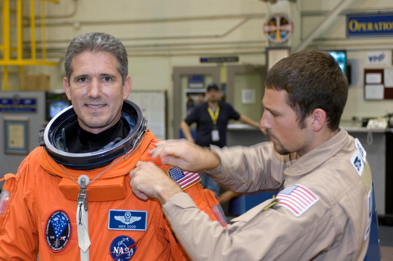 JSC2008-E-047964 (4 June 2008) --- Astronaut Michael T. Good, STS-125 mission specialist, dons a training version of his shuttle launch and entry suit in preparation for a training session in the Space Vehicle Mockup Facility at NASA's Johnson Space Center. United Space Alliance suit technician Cody McNeil assisted Good.