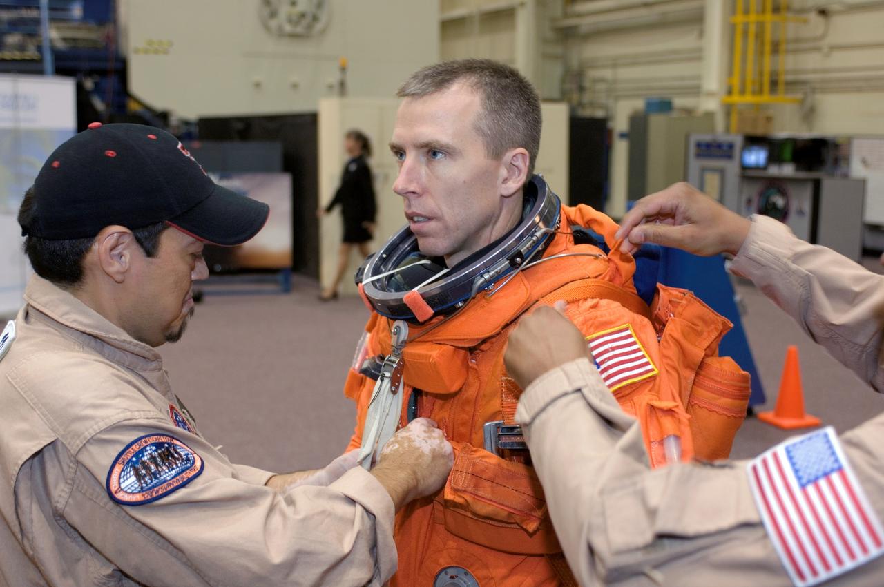 JSC2008-E-047965 (4 June 2008) --- Astronaut Andrew J. Feustel, STS-125 mission specialist, dons a training version of his shuttle launch and entry suit in preparation for a training session in the Space Vehicle Mockup Facility at NASA's Johnson Space Center. United Space Alliance suit technicians assisted Feustel.