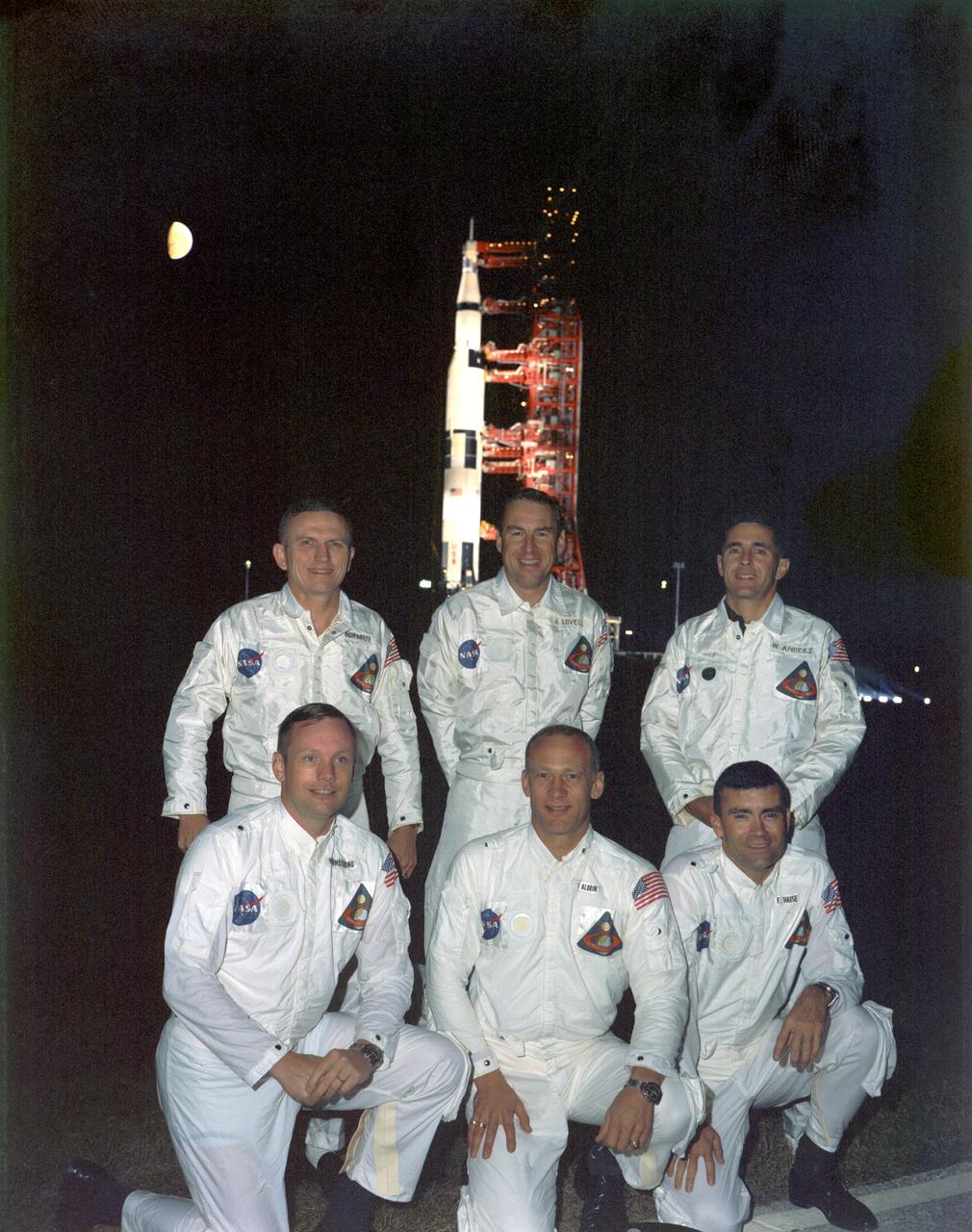    View of the Apollo 8 primary and backup crew portrait with the spacecraft at night in the background. Back row: (l.-r.) Frank Borman, commander, James A. Lovell, command module pilot and William A. Anders, lunar module pilot. Front row: (l.-r.) Neil A. Armstrong, commander, Edwin E. Aldrin, command module pilot and Fred W. Haise Jr., lunar module pilot. Original Photo number is KSC-68C-8017. 