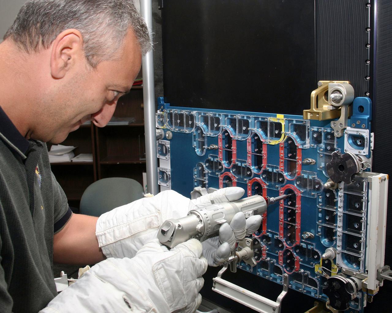 JSC2008-E-097094 (1 Aug. 2008) --- Astronaut Mike Massimino, STS-125 mission specialist, practices repairing Hubble Space Telescope hardware during a training session at NASA's Johnson Space Center.