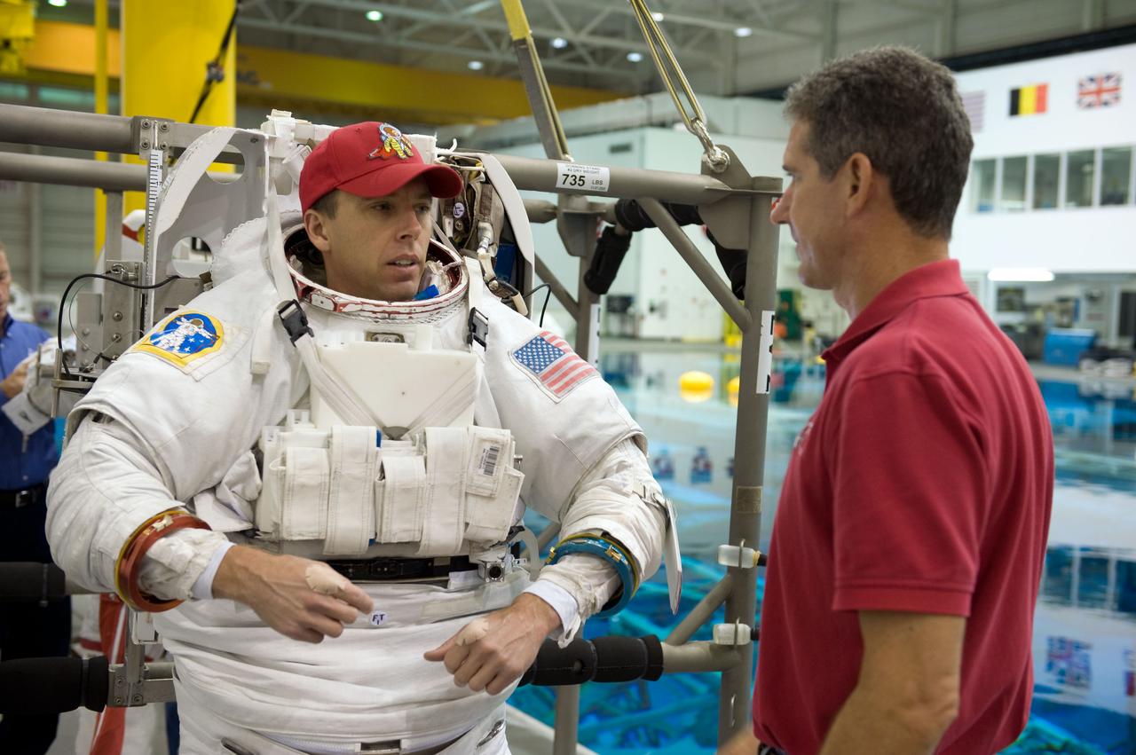 JSC2008-E-118407 (26 Sept. 2008) --- Attired in a training version of his Extravehicular Mobility Unit (EMU) spacesuit, astronaut Andrew Feustel, STS-125 mission specialist, prepares for a training session in the waters of the Neutral Buoyancy Laboratory (NBL) near NASA's Johnson Space Center. Astronaut Michael Good, mission specialist, assisted Feustel.