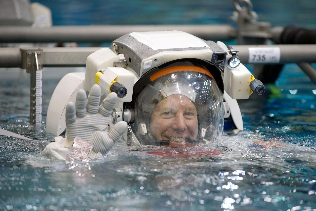 JSC2008-E-122401 (9 Oct. 2008) --- Attired in training versions of their Extravehicular Mobility Unit (EMU) spacesuits, astronauts Tim Kopra and Dave Wolf (out of frame), STS-127 mission specialists, are submerged in the waters of the Neutral Buoyancy Laboratory (NBL) near NASA's Johnson Space Center. SCUBA-equipped divers (out of frame) are in the water to assist the crewmembers in their rehearsal, intended to help prepare them for work on the exterior of the International Space Station. Kopra is scheduled to join Expedition 19 as flight engineer after launching to the International Space Station with the STS-127 crew.
