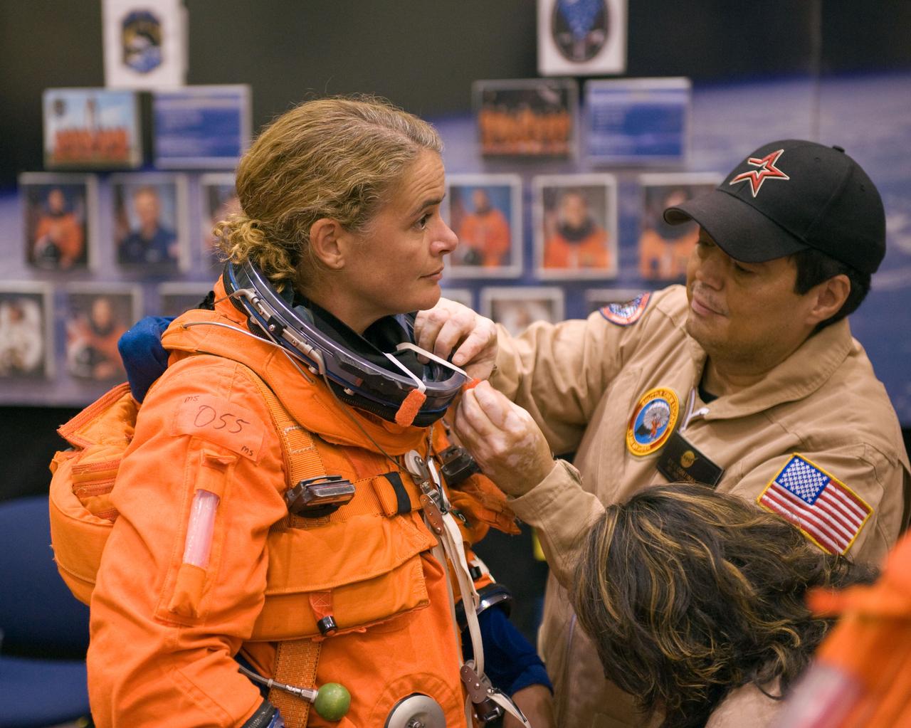 JSC2008-E-122424 (7 Oct. 2008) --- Canadian Space Agency astronaut Julie Payette, STS-127 mission specialist, dons a training version of her shuttle launch and entry suit in preparation for a training session in the Space Vehicle Mock-up Facility at NASA's Johnson Space Center. United Space Alliance suit technician Steve Cortinas assisted Payette.