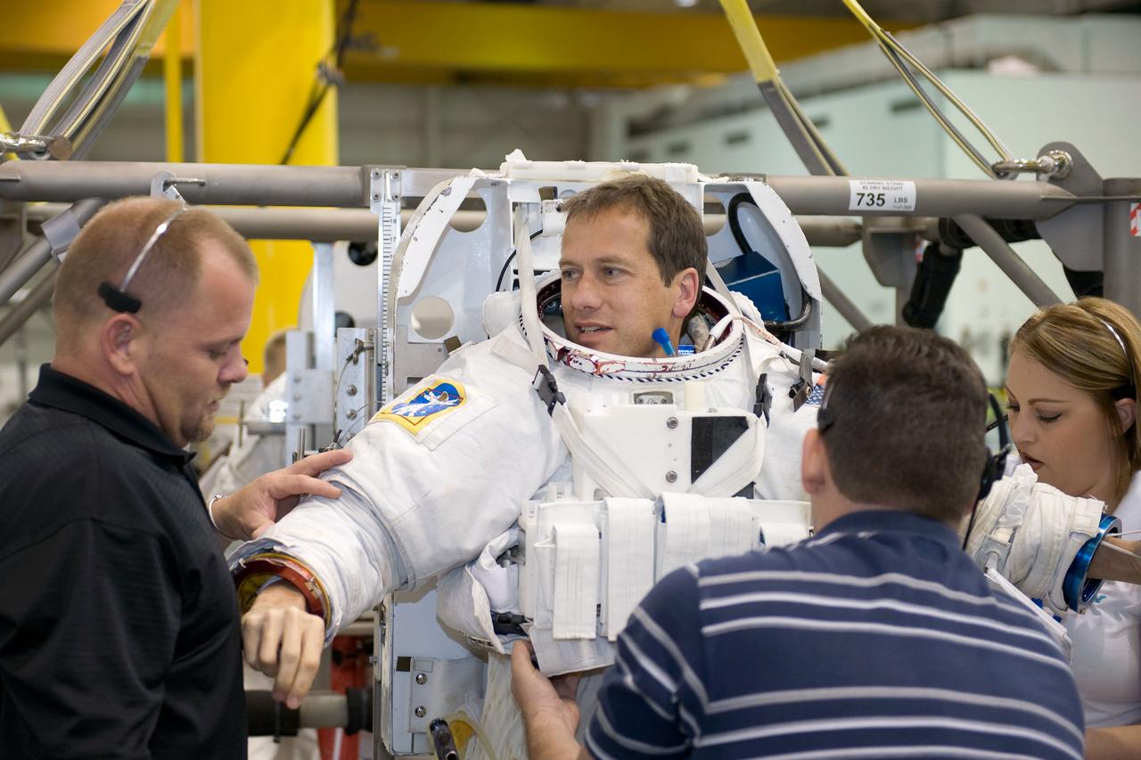 JSC2008-E-124032 (20 Oct. 2008) --- Astronaut Tom Marshburn, STS-127 mission specialist, gets help with the donning of a training version of his Extravehicular Mobility Unit (EMU) spacesuit in preparation for a training session in the waters of the Neutral Buoyancy Laboratory (NBL) near NASA's Johnson Space Center.