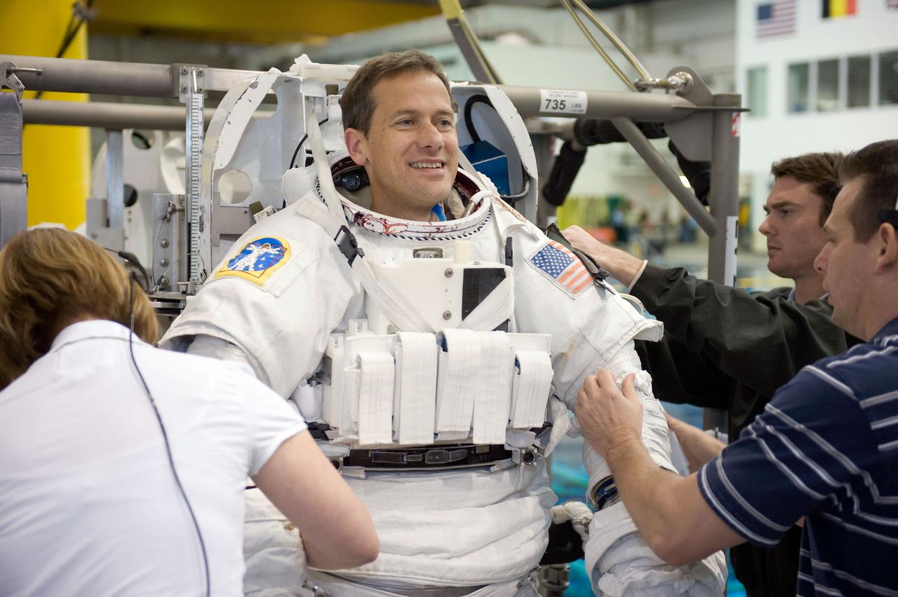 JSC2008-E-124036 (20 Oct. 2008) --- Astronaut Tom Marshburn, STS-127 mission specialist, gets help with the donning of a training version of his Extravehicular Mobility Unit (EMU) spacesuit in preparation for a training session in the waters of the Neutral Buoyancy Laboratory (NBL) near NASA's Johnson Space Center.