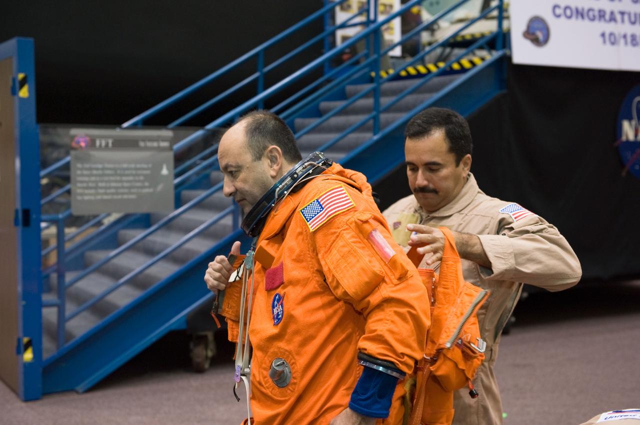 JSC2008-E-139778 (12 Nov. 2008) --- Astronaut Mark Polansky, STS-127 commander, dons a training version of his shuttle launch and entry suit in preparation for a training session in the Space Vehicle Mock-up Facility at NASA's Johnson Space Center. United Space Alliance (USA) suit technician Raymond Cuevas assisted Polansky.