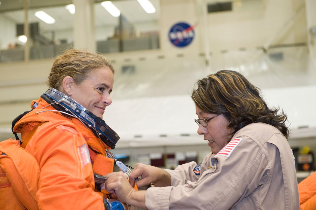 JSC2008-E-139785 (12 Nov. 2008) --- Canadian Space Agency astronaut Julie Payette, STS-127 mission specialist, gets help in the donning of her shuttle launch and entry suit in preparation for a training session in the Space Vehicle Mock-up Facility at NASA's Johnson Space Center.