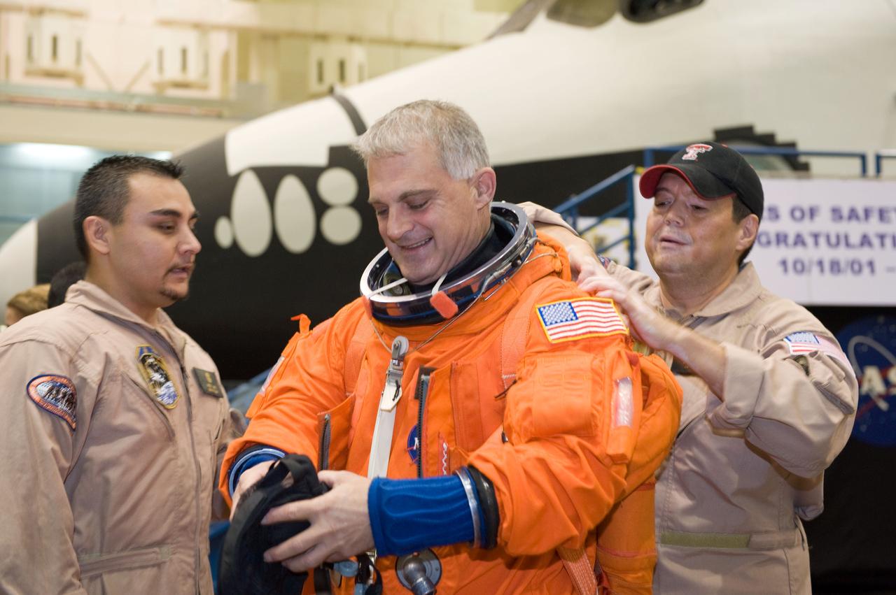 JSC2008-E-139786 (12 Nov. 2008) --- Astronaut Dave Wolf, STS-127 mission specialist, dons a training version of his shuttle launch and entry suit in preparation for a training session in the Space Vehicle Mock-up Facility at NASA's Johnson Space Center. United Space Alliance (USA) suit technicians Steve Cortinas (right) and Russ Baker assisted Wolf.