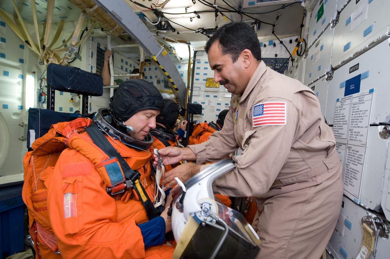 JSC2008-E-139797 (12 Nov. 2008) --- Astronauts Tim Kopra (left), Dave Wolf (partially obscured) and Christopher Cassidy (mostly obscured), all STS-127 mission specialists, participate in a training session in one of the full-scale trainers in the Space Vehicle Mock-up Facility at NASA's Johnson Space Center. Attired in training versions of their shuttle launch and entry suits, the three are seated on the middeck for a post insertion/de-orbit training session. United Space Alliance (USA) suit technician Raymond Cuevas assisted the crewmembers. Kopra is scheduled to join Expedition 19 as flight engineer after launching to the International Space Station with the STS-127 crew.