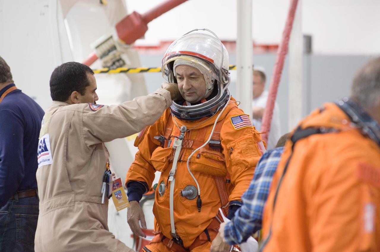 JSC2008-E-155152 (12 Dec. 2008) --- Astronaut Mark Polansky, STS-127 commander, dons a training version of his shuttle launch and entry suit in preparation for a water survival training session in the Neutral Buoyancy Laboratory (NBL) near NASA?s Johnson Space Center. United Space Alliance suit technician Raymond Cuevas assisted Polansky.