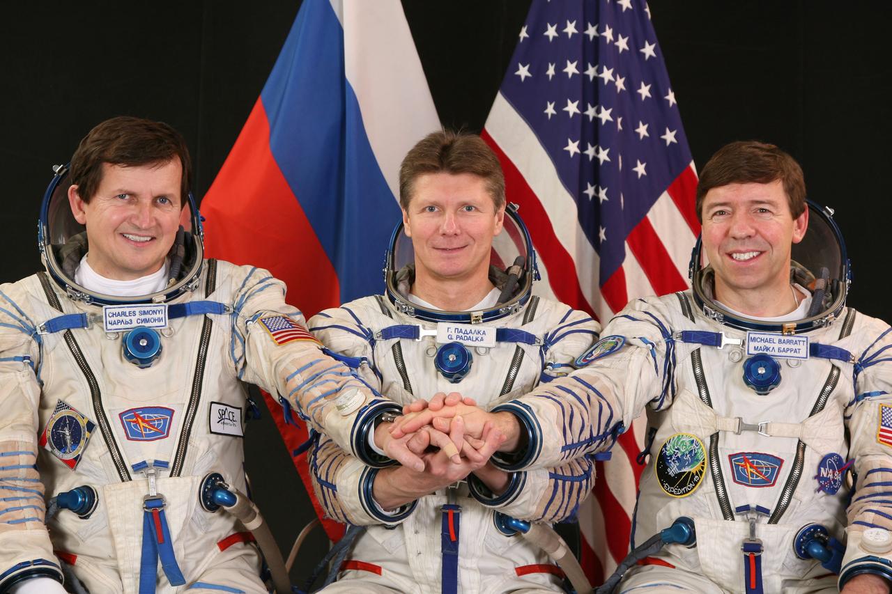 JSC2009-E-049820 (February 2009) --- Attired in Russian Sokol launch and entry suits, cosmonaut Gennady Padalka (center), Expedition 19/20 commander; astronaut Michael Barratt (right), Expedition 19/20 flight engineer; and U.S. spaceflight participant Charles Simonyi join hands as they pose for a portrait in Star City, Russia. Photo credit: Gagarin Cosmonaut Training Center