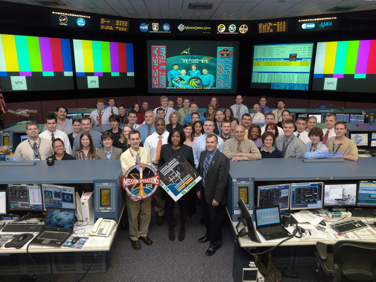 JSC2009-E-061164 (20 March 2009) --- The members of the STS-119/15A ISS Orbit 3 flight control team pose for a group portrait in the space station flight control room in the Mission Control Center at NASA’s Johnson Space Center. Flight director David Korth (right) is visible on the front row.