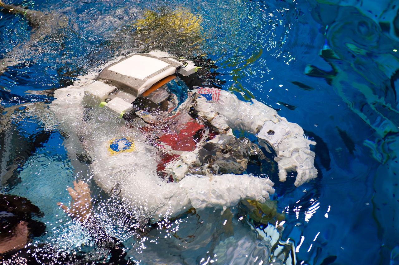 PHOTO DATE: 04-10-09 LOCATION: NBL - Pool Topside and Control Room SUBJECT: STS-129 crew members Michael Foreman and Robert Satcher during STS-129 ULF3 EVA 1 92027 training. Photograph preparations, getting in suit, working with suit techs, being lowered into water, other crew members in control room PHOTOGRAPHER: Devin Boldt
