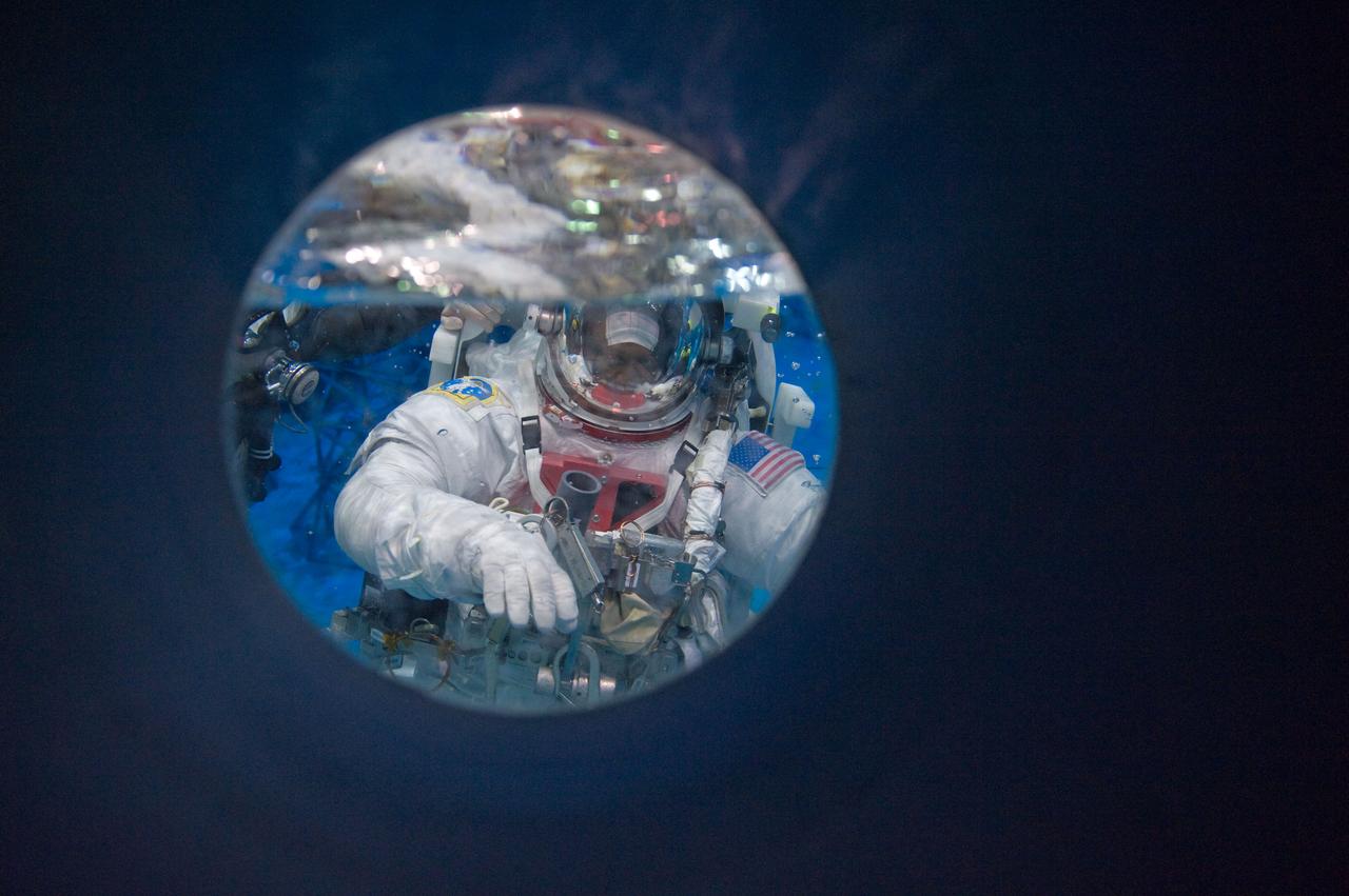 PHOTO DATE: 04-10-09 LOCATION: NBL - Pool Topside and Control Room SUBJECT: STS-129 crew members Michael Foreman and Robert Satcher during STS-129 ULF3 EVA 1 92027 training. Photograph preparations, getting in suit, working with suit techs, being lowered into water, other crew members in control room PHOTOGRAPHER: Devin Boldt