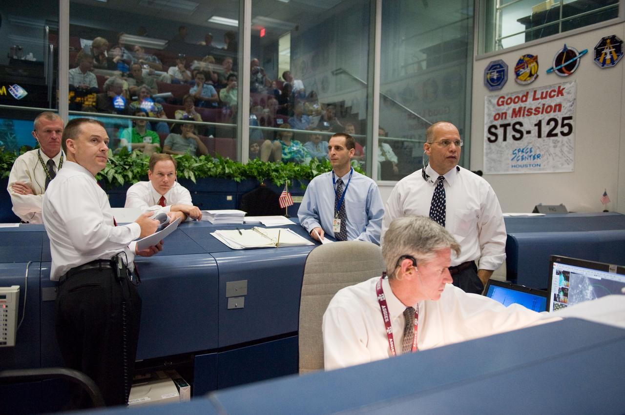 JSC2009-E-118818 (11 May 2009) --- Flight directors Bryan Lunney (seated at right), Norm Knight (left foreground) and Tony Ceccacci (standing, far right); along with Brent Jett (left background), director, flight crew operations; and John McCullough (seated, background), chief of the flight director office, are pictured in the space shuttle flight control room in the Mission Control Center at NASA's Johnson Space Center during launch countdown activities a few hundred miles away in Florida, site of Space Shuttle Atlantis? scheduled STS-125 launch to service the Hubble Space Telescope. Liftoff was on time at 2:01 p.m. (EDT) on May 11, 2009 from launch pad 39A at NASA's Kennedy Space Center.
