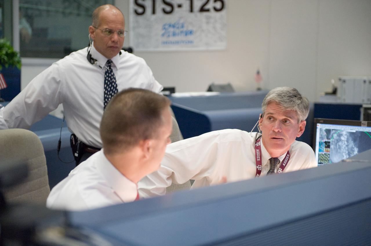 JSC2009-E-118879 (11 May 2009) --- Flight directors Norm Knight (left), Bryan Lunney and Tony Ceccacci (standing) are pictured in the space shuttle flight control room in the Mission Control Center at NASA's Johnson Space Center during launch countdown activities a few hundred miles away in Florida, site of Space Shuttle Atlantis? scheduled STS-125 launch to service the Hubble Space Telescope. Liftoff was on time at 2:01 p.m. (EDT) on May 11, 2009 from launch pad 39A at NASA's Kennedy Space Center.