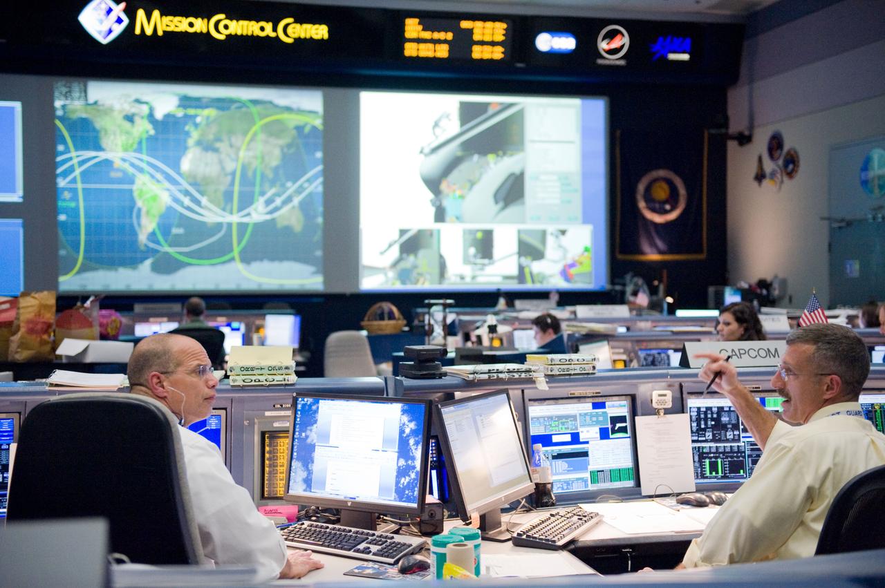 JSC2009-E-120483 (14 May 2009) --- Flight director Tony Ceccacci (left) and astronaut Dan Burbank, STS-125 spacecraft communicator (CAPCOM), are pictured at their consoles in the space shuttle flight control room in the Mission Control Center at NASA's Johnson Space Center during flight day four activities.