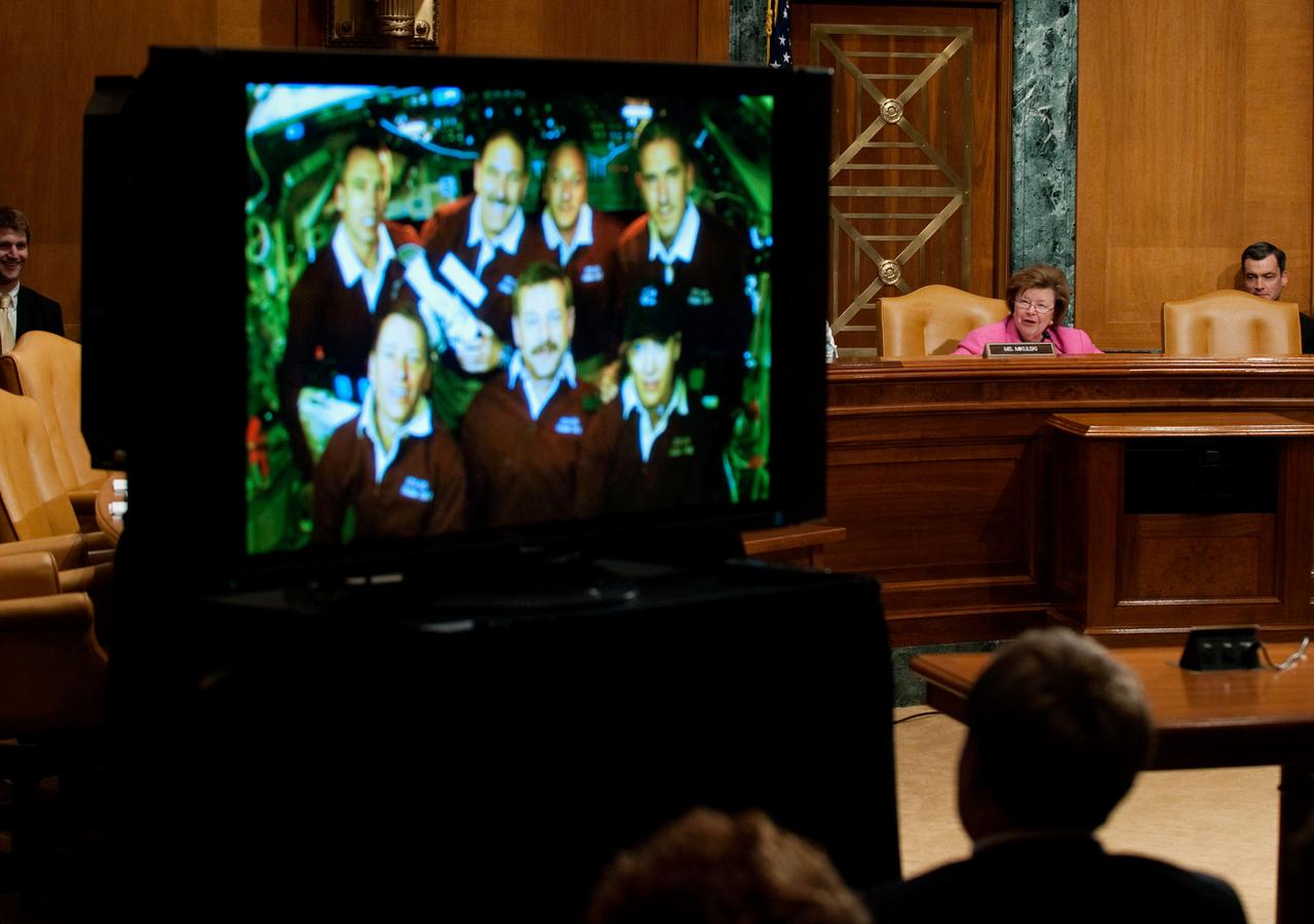 JSC2009-E-121339 (21 May 2009) --- The astronaut crewmembers of the STS-125 flight orbiting Earth aboard the Space Shuttle Atlantis are seen on a TV screen as they receive a phone call from U.S. Senator Barbara Mikulski (D-Md.) the day after the crew released the freshly serviced Hubble Space Telescope. Photo credit: NASA/Paul Alers
