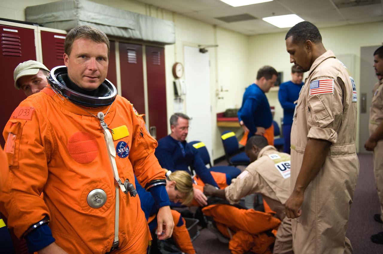 JSC2009-E-125123 (1 June 2009) --- Astronaut Terry Virts Jr. (left), STS-130 pilot, attired in a training version of his shuttle launch and entry suit, prepares for a training session in the Space Vehicle Mock-up Facility at NASA?s Johnson Space Center.