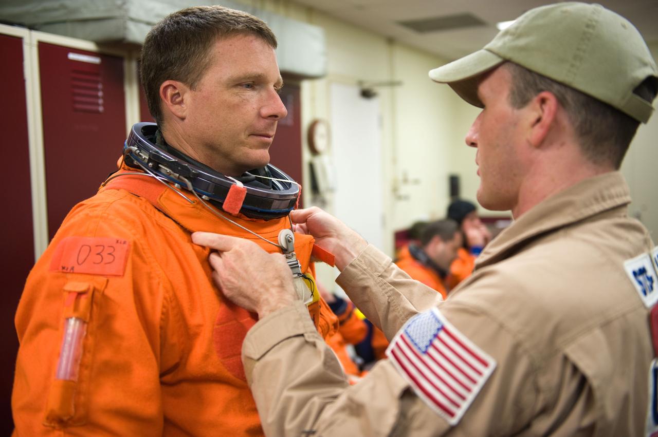 JSC2009-E-125128 (1 June 2009) --- Astronaut Terry Virts Jr., STS-130 pilot, gets helps with the donning of a training version of his shuttle launch and entry suit in preparation for a training session in the Space Vehicle Mock-up Facility at NASA?s Johnson Space Center.