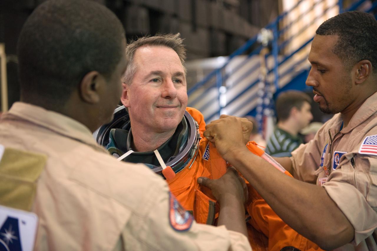 JSC2009-E-125140 (1 June 2009) --- Astronaut Stephen Robinson, STS-130 mission specialist, gets helps with the donning of a training version of his shuttle launch and entry suit in preparation for a training session in the Space Vehicle Mock-up Facility at NASA?s Johnson Space Center.