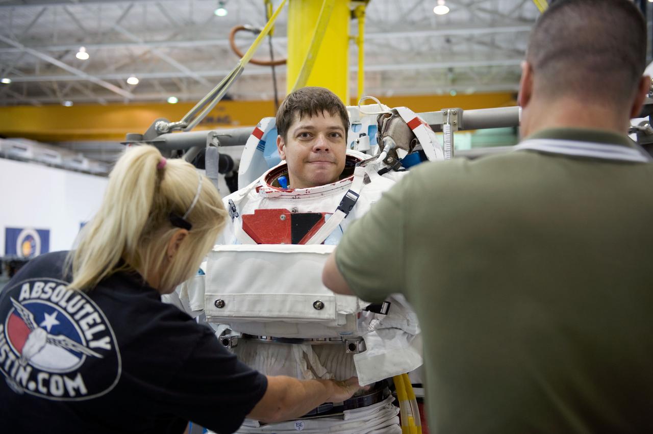 JSC2009-E-145694 (17 July 2009) --- Astronaut Robert Behnken, STS-130 mission specialist, gets help in the donning of a training version of his Extravehicular Mobility Unit (EMU) spacesuit in preparation for a spacewalk training session in the waters of the Neutral Buoyancy Laboratory (NBL) near NASA's Johnson Space Center.