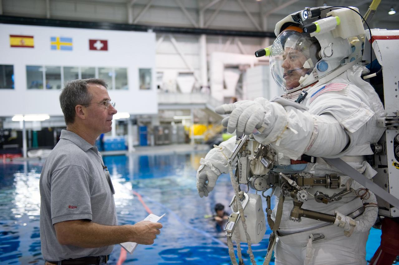 JSC2009-E-145713 (17 July 2009) --- Astronaut Robert Behnken, STS-130 mission specialist, attired in a training version of his Extravehicular Mobility Unit (EMU) spacesuit, prepares for a spacewalk training session in the waters of the Neutral Buoyancy Laboratory (NBL) near NASA's Johnson Space Center. Astronaut Stephen Robinson, mission specialist, assisted Behnken.