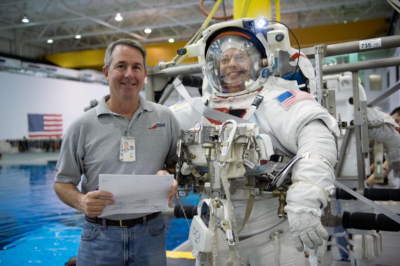 JSC2009-E-145714 (17 July 2009) --- Astronaut Robert Behnken, attired in a training version of his Extravehicular Mobility Unit (EMU) spacesuit, and astronaut Stephen Robinson, both STS-130 mission specialists, pose for a photo as they prepare for a spacewalk training session in the waters of the Neutral Buoyancy Laboratory (NBL) near NASA's Johnson Space Center.