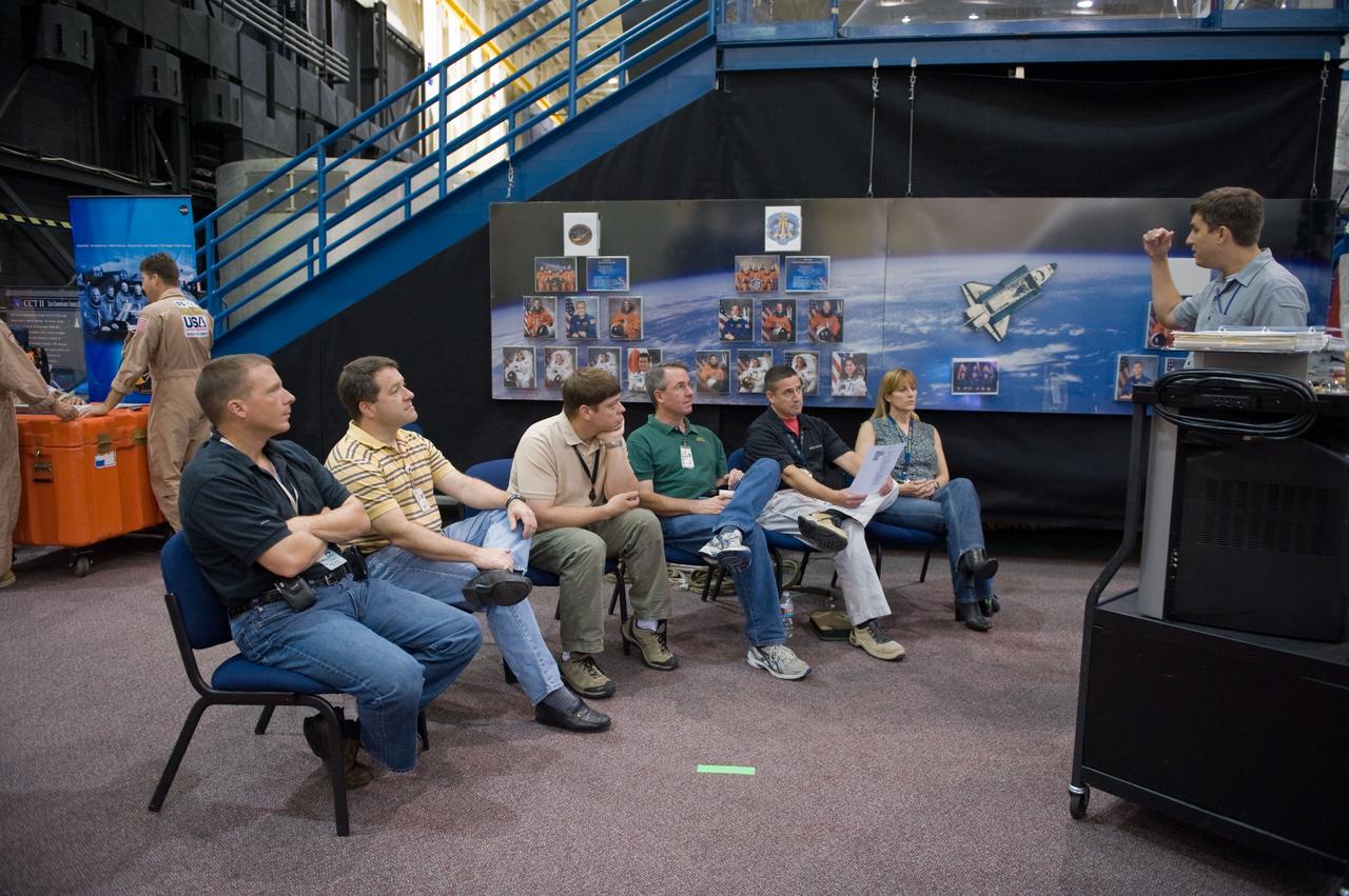 JSC2009-E-146817 (21 July 2009) --- The STS-130 crew members are pictured as they prepare for a training session in the Space Vehicle Mock-up Facility at NASA?s Johnson Space Center. Seated from the left are astronauts Terry Virts Jr., STS-130 pilot; Nicholas Patrick, Robert Behnken, Stephen Robinson, all mission specialists; George Zamka, commander; and Kathryn Hire, mission specialist.