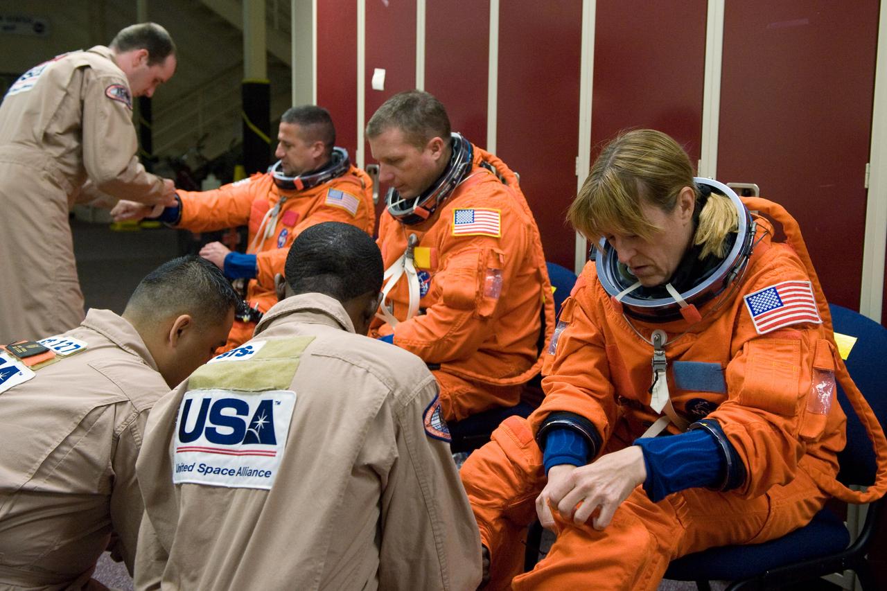 JSC2009-E-146832 (21 July 2009) --- Astronauts Kathryn Hire, STS-130 mission specialist; Terry Virts Jr. (center), pilot; and George Zamka, commander, don training versions of their shuttle launch and entry suits in preparation for a training session in the Space Vehicle Mock-up Facility at NASA?s Johnson Space Center. United Space Alliance suit technicians assisted the crew members.