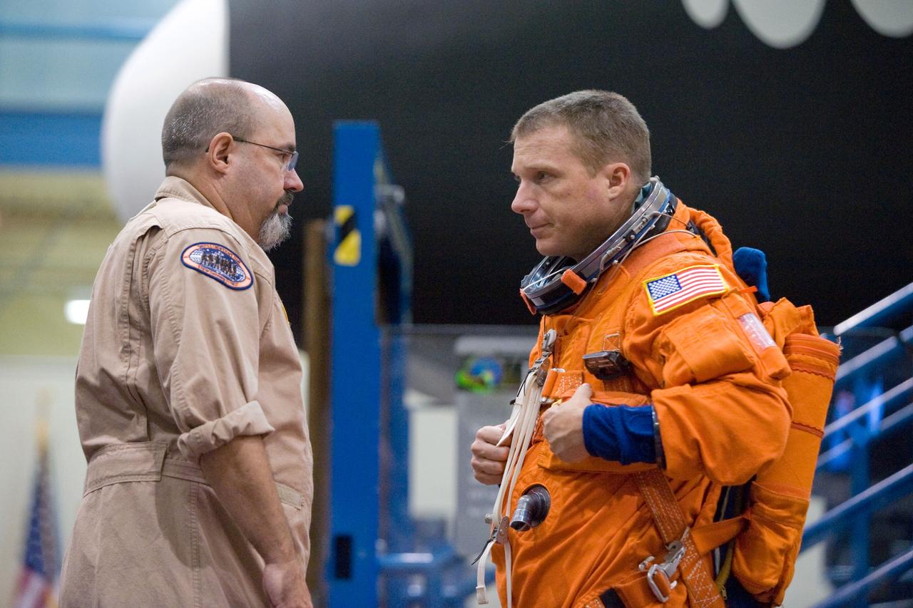 JSC2009-E-146838 (21 July 2009) --- Astronaut Terry Virts Jr., STS-130 pilot, attired in a training version of his shuttle launch and entry suit, participates in a training session in the Space Vehicle Mock-up Facility at NASA?s Johnson Space Center. United Space Alliance suit technician Fred Utley assisted Virts.